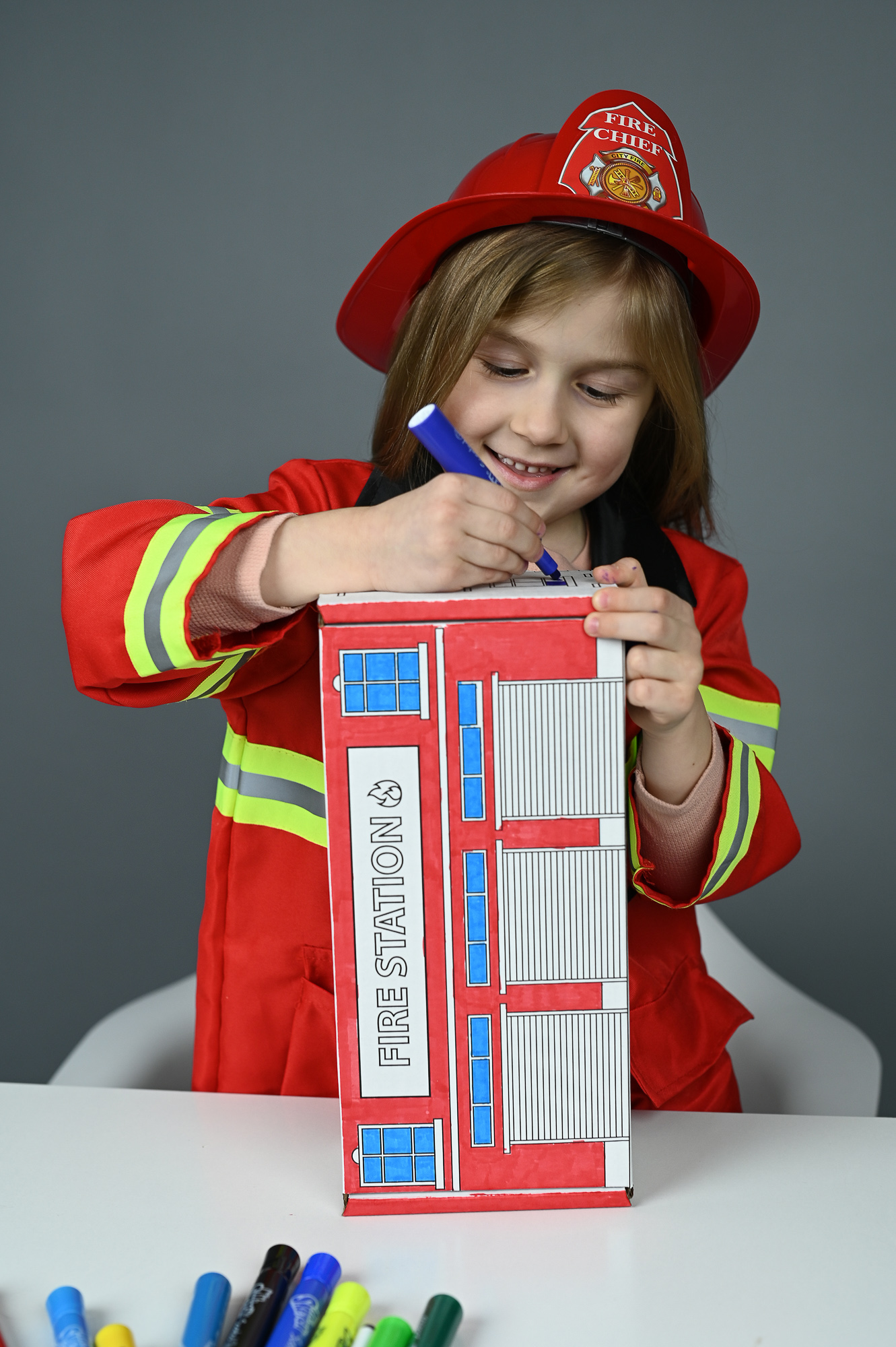 A child coloring the Fire Station box stood upright like a tall building